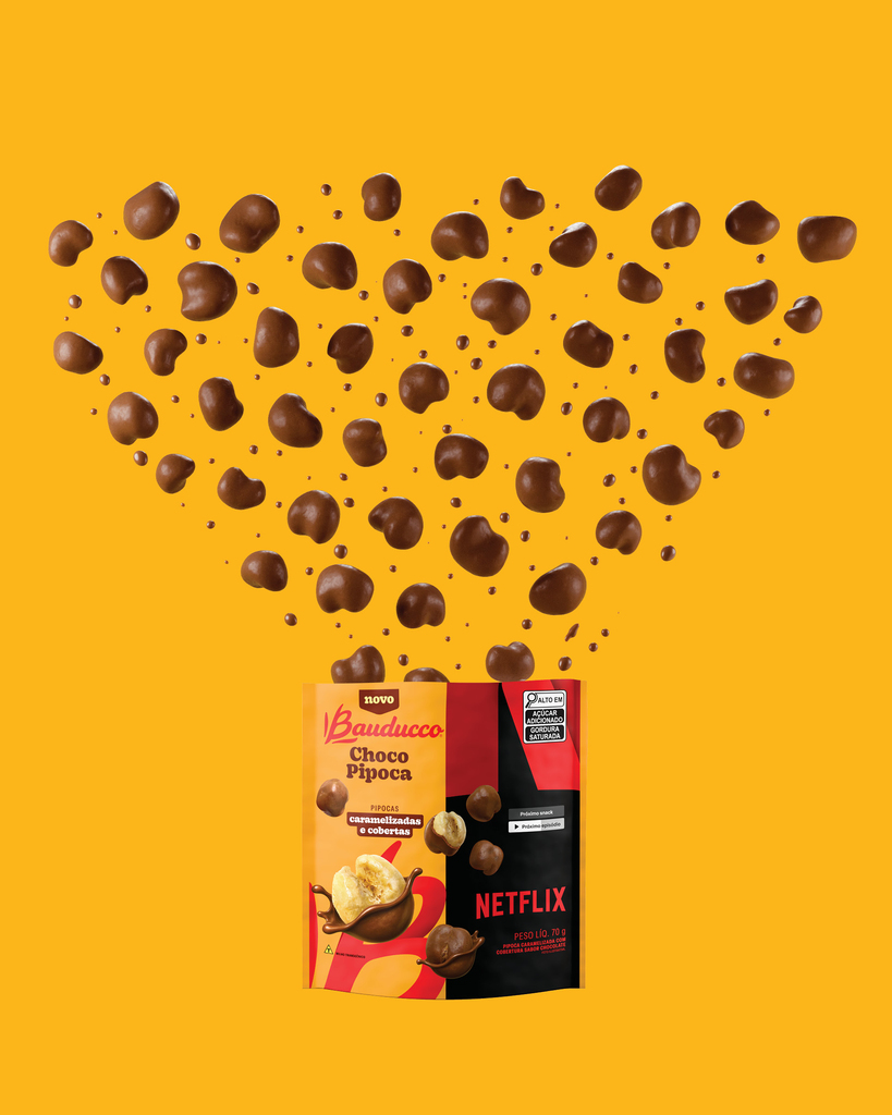 Pipocas cobertas de chocolate caindo sobre a embalagem do Bauducco Choco Pipoca