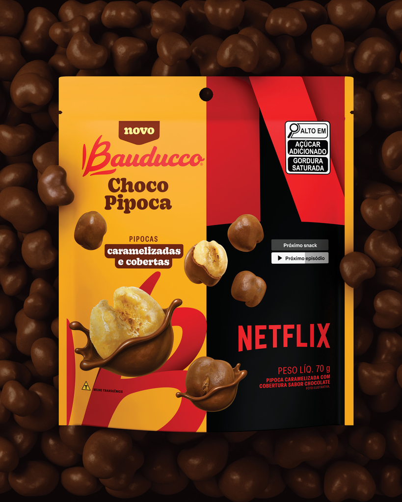 Embalagem do Bauducco Choco Pipoca sobre leito de pipocas cobertas de chocolate